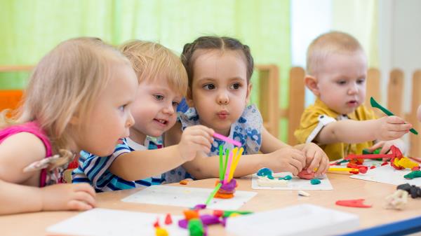 Kids group making arts and crafts in kindergarten.