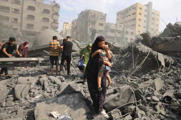 Palestinians evacuate the area following an Israeli airstrike on the Sousi mosque in Gaza City Monday.