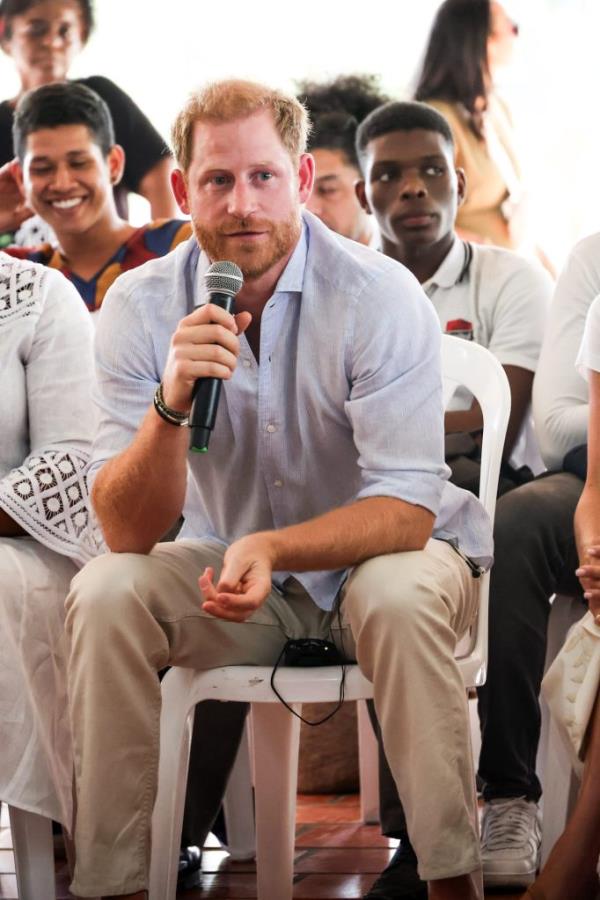 Prince Harry, Duke of Sussex, sitting in a chair holding a microphone during his visit at Unidad Recreativa El Vallado, Cali, Colombia on August 18, 2024.