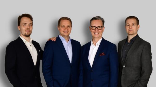 AN image of the four men in the QMill founding team, all wearing suits