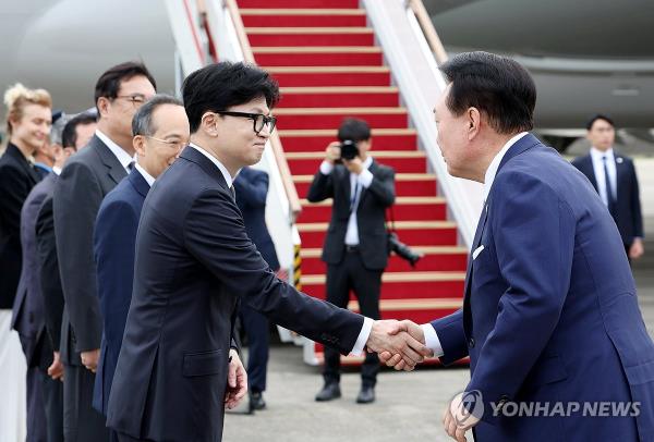 President Yoon Suk Yeol (R) shakes hands with Han Dong-hoon, leader of the ruling People Power Party, on Sept. 19, 2024, as Yoon departs for the Czech Republic at Seoul Air base in Seongnam. (Yonhap)