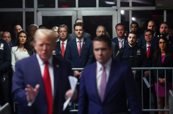 Rep. Anna Paulina Luna (back left)(R-FL), Rep. Matt Gaetz (back Center)(R-FL), Rep. Andy Biggs (back second left)(R-AZ) and Rep. Lauren Boebert (back right)(R-CO) look on as former US President Donald Trump (L) speaks to the press before his trial for allegedly covering up hush money payments linked to extramarital affairs, at Manhattan Criminal Court in New York City, on May 16, 2024.