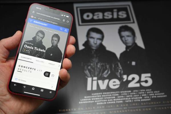 一位粉丝使用智能手机访问在线售票网站，购买绿洲乐队2025年“Live '25”巡演的门票，地点在英格兰北部的马斯登，演出时间为2024年8月31日。