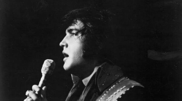 Elvis on stage with mic in jeweled outfit