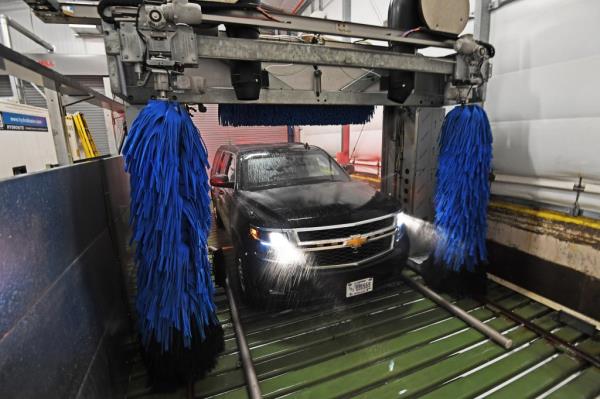 A black USSS vehicle being cleaned in a car washer