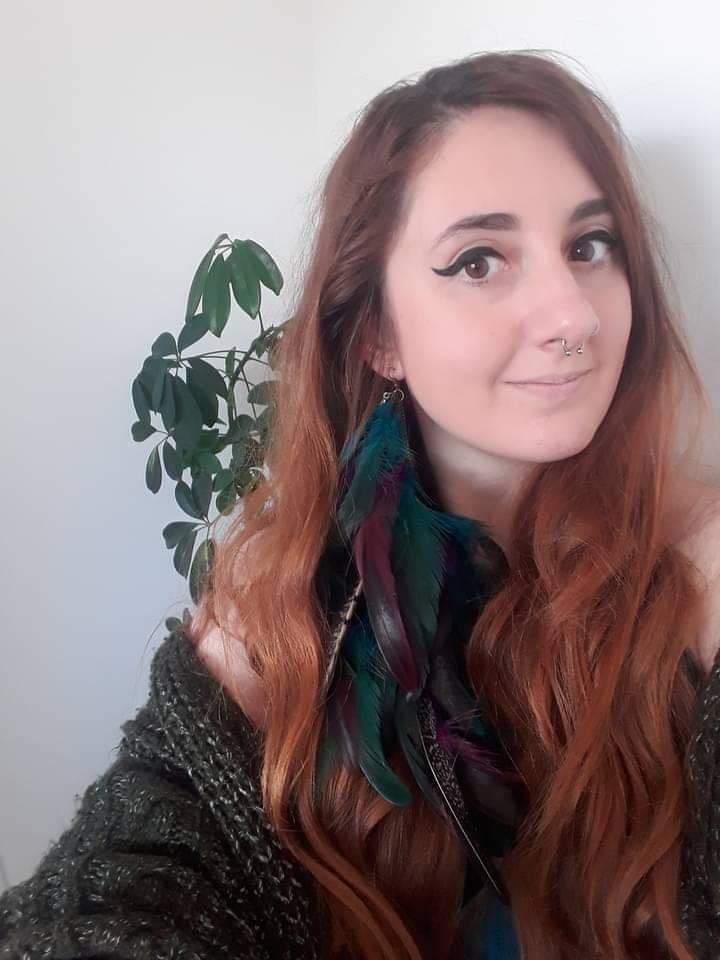Lowri Llewelyn穿着绿色毛衣站在植物前