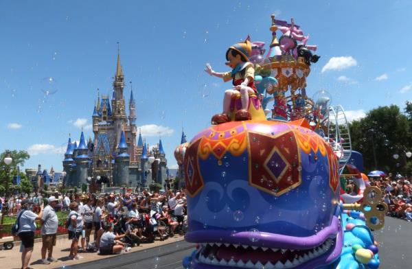 disney world with cinderella's castle in the background and pinocchio riding a float in the foreground