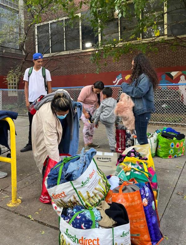 children out ona. sidewalk with bags stuffed with belongings
