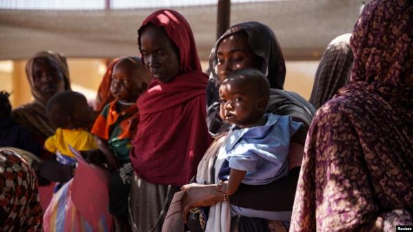 FILE - Women and babies wait at the Zamzam displacement camp, home to 400,000 people, in North Darfur, Sudan, in January 2024. (Medecins Sans Frontieres via Reuters)