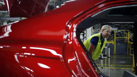 Getty Images Plant manager looks at vehicle on an assembly line at the Toyota factory in Georgetown, Kentucky.