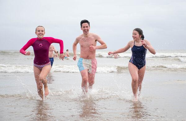 Caoimhe Walsh, James Cotter and Lucy Kelleher from Killeagh seen running in from the cold water during the Christmas Day Swim on the Front Strand in Youghal. Picture: Howard Crowdy Caoimhe Walsh, James Cotter and Lucy Kelleher from Killeagh seen running in from the cold water during the Christmas Day Swim on the Front Strand in Youghal. Picture: Howard Crowdy