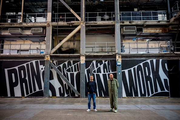 Two men stand in the empty building of printworks