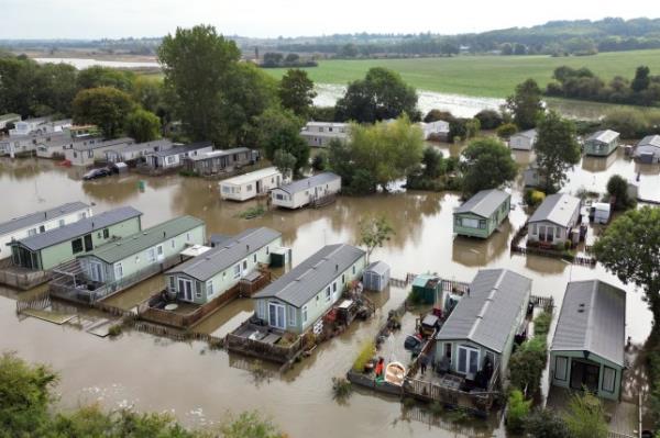 People can be seen wading in their gardens as Cogenhoe Mill Holiday Park in Northamptonshire is submerged by floodwater after the River Nene burst its banks. 35 flood warnings are in place across England on Tuesday morning. Parts of Bedfordshire, Oxfordshire, Warwickshire and Northamptonshire saw more than 100mm of rain in the last 48 hours. Picture date: Tuesday September 24, 2024. PA Photo. See PA story WEATHER Rain. Photo credit should read: Joe Giddens/PA Wire