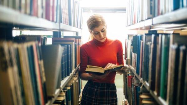 woman reading a book in a library