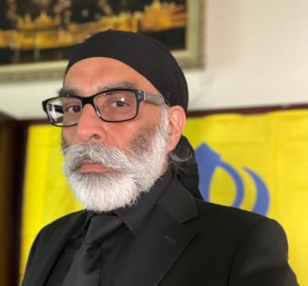 a man with a beard in glasses and a black suit and tie