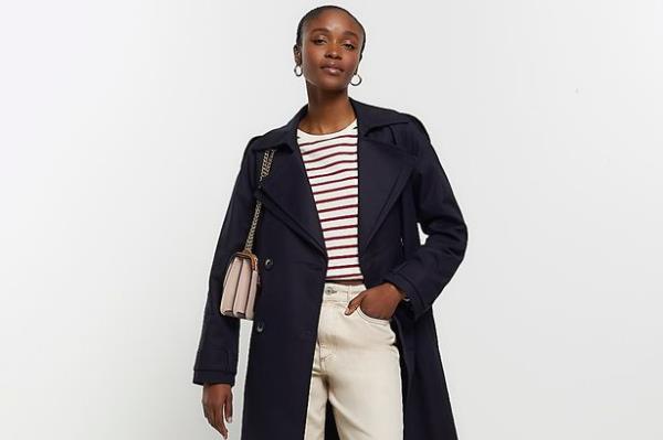 Woman wearing the River Island trench coat in black